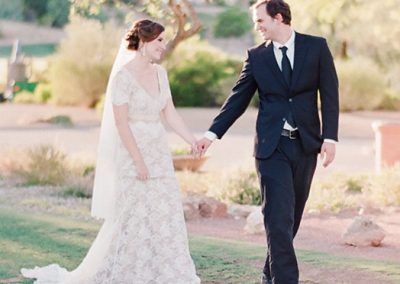 A man and woman walking in the grass.