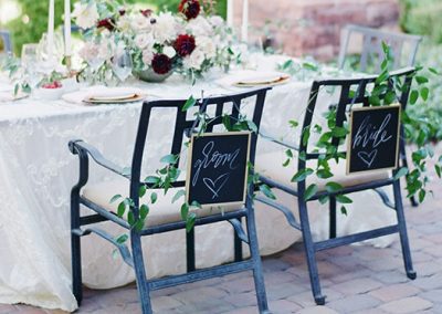 Two chairs are sitting at a table with flowers.