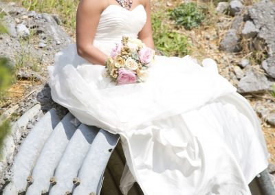 A bride sitting on top of a pipe.