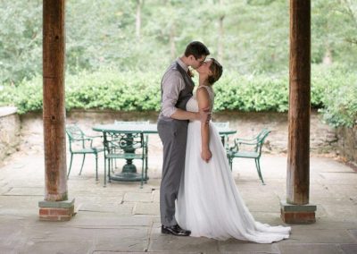 A bride and groom kissing under an archway.