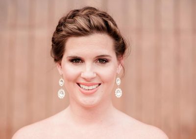 A woman with long earrings smiles for the camera.