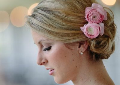 A woman with blonde hair and pink flowers in her hair.