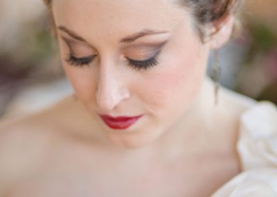 A woman with red lipstick and white dress.