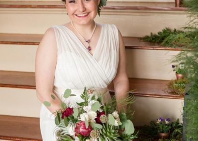 A woman holding flowers in her hand and smiling.