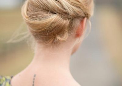 A woman with blonde hair is wearing a floral dress.