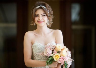 A bride holding her bouquet of flowers in front of the camera.