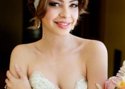 A beautiful woman in a white dress holding flowers.