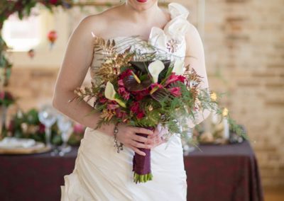 A bride holding her bouquet in front of the table.