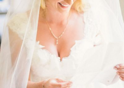 A bride in her wedding dress looking at the camera.