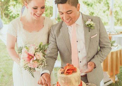 A man and woman cutting their wedding cake.