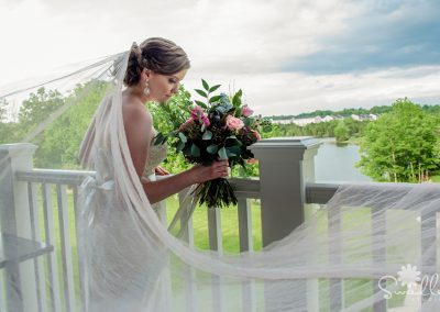 A bride holding her bouquet on the deck of her wedding.