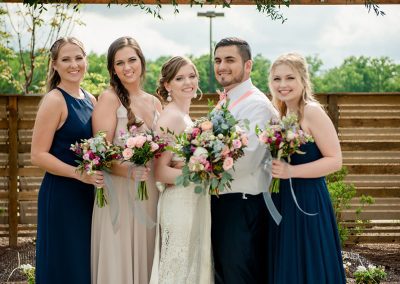 A group of people standing under an arbor.