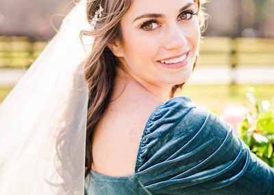 A woman in blue dress with veil and flowers.