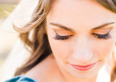 A woman with long eyelashes looking down at her face.