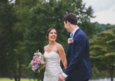 A bride and groom laughing together outside