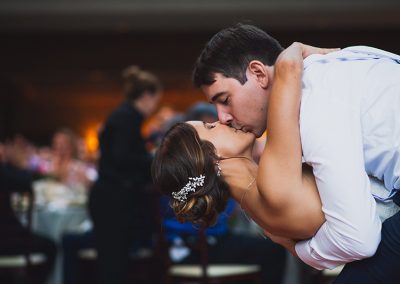 A man and woman kissing in front of a crowd.