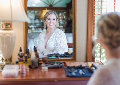 A woman is looking at her reflection in the mirror.