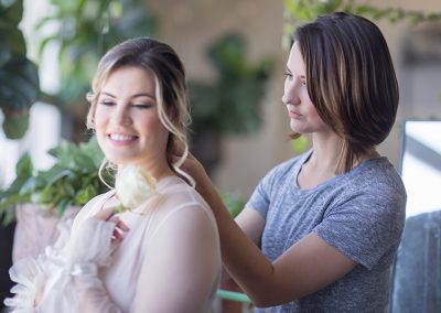 A woman is helping another woman with her hair.