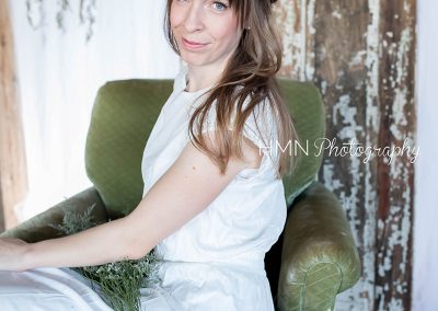 A woman sitting in a chair holding flowers.