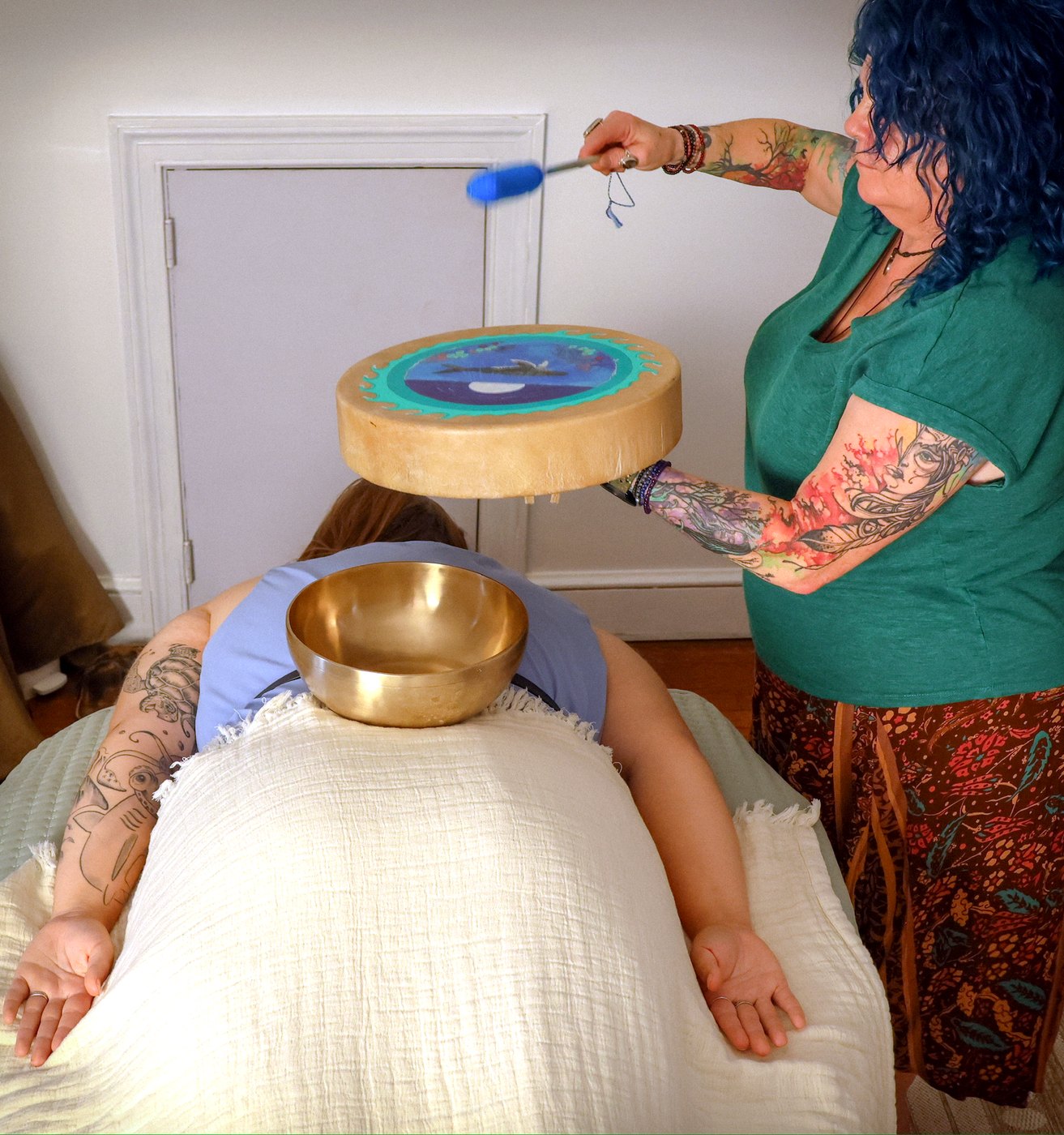 Sound bath with a Tibetan singing bowl resting on the body during a vibrational healing session at Enlightened Styles in Warrenton, VA